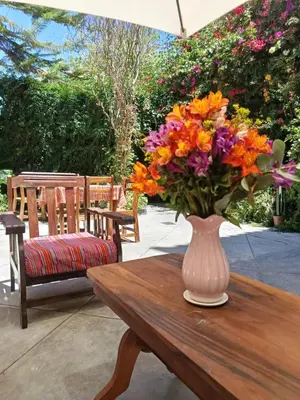 a vase of flowers sitting on a wooden table at Casa Munayki in Ayacucho