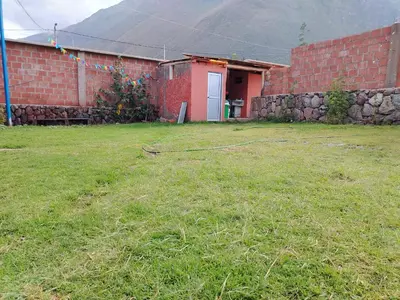 a yard with a building and a brick wall at Hotel House in Perú 2 in Urubamba