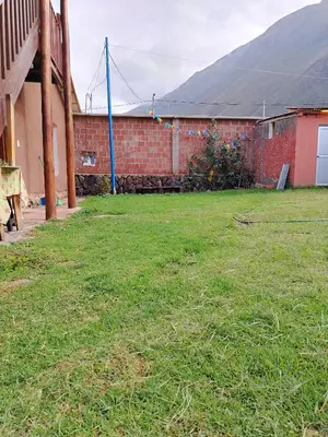 a yard with a building and a brick wall at Hotel House in Perú 2 in Urubamba