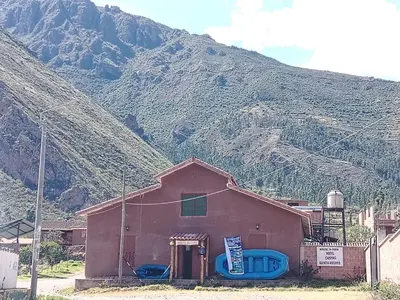 a small building with a mountain in the background at Hotel House in Perú 2 in Urubamba