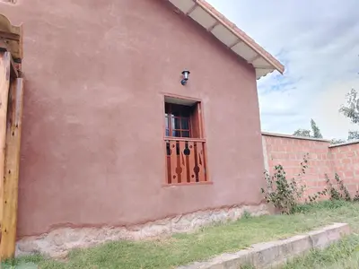 a pink house with a door and a window at Hotel House in Perú 2 in Urubamba