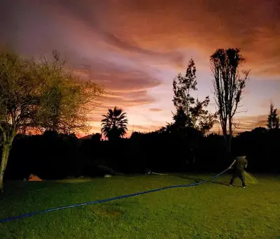 a person flying a kite in a field at sunset at Casa de Campo con lago en Mala in Mala