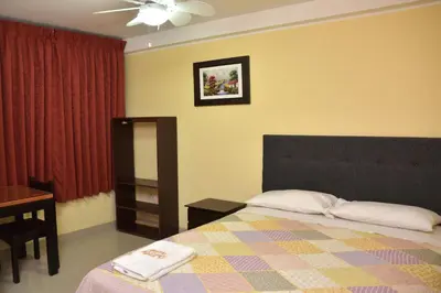 a bedroom with a bed and a dresser and a table at hostal kiara in Huairona