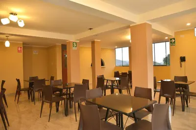 a dining room with tables and chairs and windows at hostal kiara in Huairona