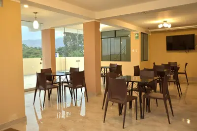 a dining room with tables and chairs and a tv at hostal kiara in Huairona