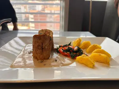 a plate of food with meat and potatoes on a table at Waranway Lodge Huayopata in Quillabamba