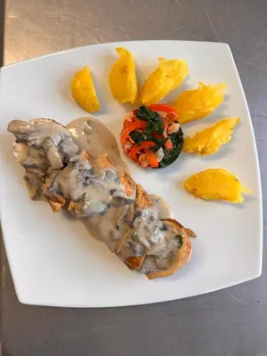 a plate of food with meat and vegetables on it at Waranway Lodge Huayopata in Quillabamba