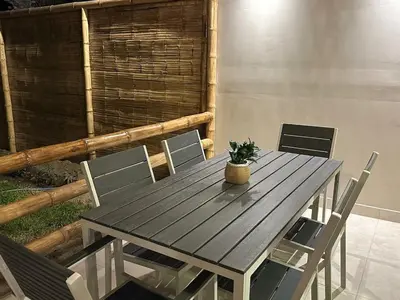 a wooden table with chairs and a potted plant on it at Casa Paraquitas 