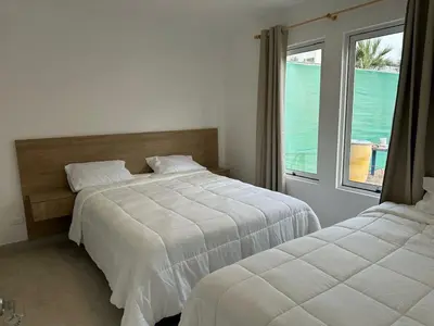 a bedroom with two beds and a large window at Casa Paraquitas 
