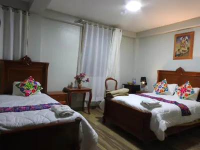 a bedroom with two beds and a window at Rumi Wasi Inn Ollantaytambo in Ollantaytambo