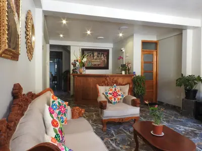 a living room with a couch and two chairs at Rumi Wasi Inn Ollantaytambo in Ollantaytambo