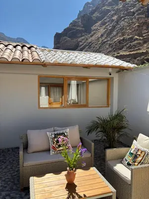 a patio with a couch and chairs and a table at Rumi Wasi Inn Ollantaytambo in Ollantaytambo