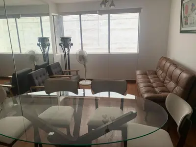 a living room with a glass table and a couch at Departamento en Miraflores in Lima