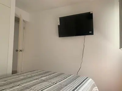a flat screen tv on the wall of a bedroom at Departamento en Miraflores in Lima