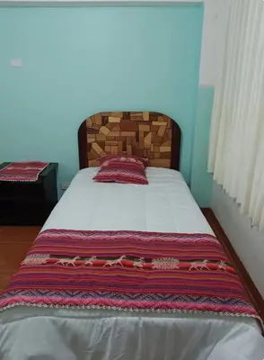 a bedroom with a large bed with a wooden headboard at Añay Ayllu in Cusco