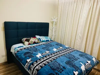 a bedroom with a bed with a blue comforter at El encanto de viajar in Lima