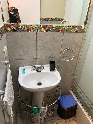 a bathroom with a white sink and a mirror at El encanto de viajar in Lima