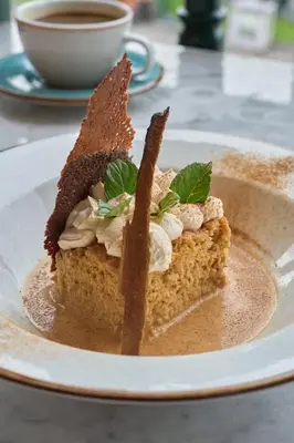 a piece of cake on a plate with a cup of coffee at Casa Andina Standard Ayacucho in Ayacucho