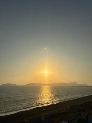 a sunset on the beach with the sun setting at Modern and comfortable apartment nearby Aairport in Lima
