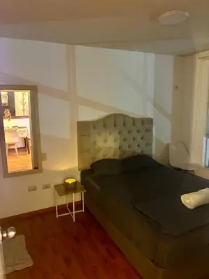 a bedroom with a bed and a mirror and a table at Modern and comfortable apartment nearby Aairport in Lima