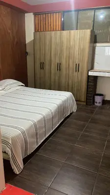 a bedroom with a large bed and wooden cabinets at Residencial Misky Dreams in Huánuco