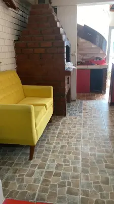 a yellow couch in a room with a brick wall at Residencial Misky Dreams in Huánuco