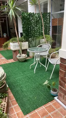 a patio with a table and chairs on grass at Residencial Misky Dreams in Huánuco