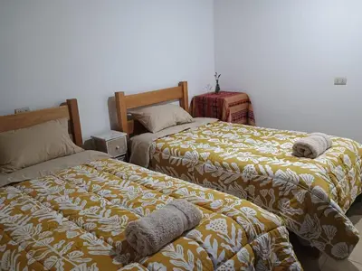 two beds sitting next to each other in a bedroom at Casa Qantu Huaytará in Huaytará
