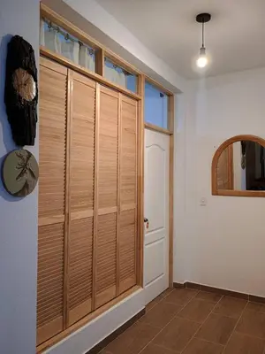 a room with a large wooden closet with a door at Casa Qantu Huaytará in Huaytará