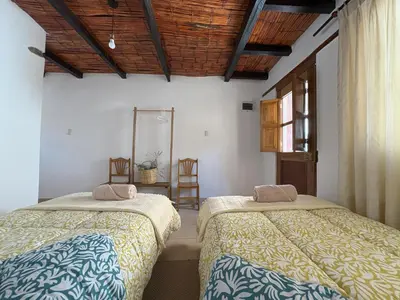 a bedroom with two beds and a mirror on the wall at Casa Qantu Huaytará in Huaytará