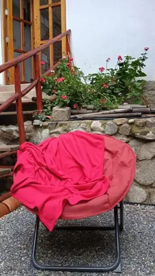 a red chair with a blanket on top of it at Casa Qantu Huaytará in Huaytará