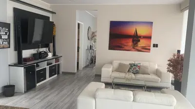 a living room with two white couches and a flat screen tv at Dolphin house 915 in Punta Negra