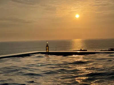 a bottle of beer sitting on the edge of a swimming pool at Dolphin house 915 in Punta Negra