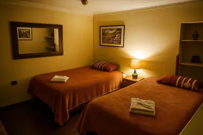 a hotel room with two beds and a mirror at Panay Golden in Cusco