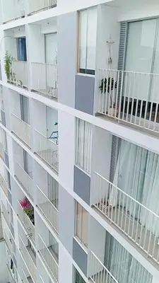 a white apartment building with balconies at Se alquila habitación con cama King y baño privado in Lima