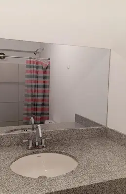 a bathroom counter with a sink and a mirror at Se alquila habitación con cama King y baño privado in Lima