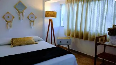 a bedroom with a bed and a lamp and a window at Apart Hotel Nazarenas in Ayacucho