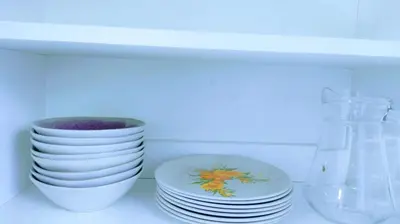 a stack of plates and bowls sitting on a shelf at Apart Hotel Nazarenas in Ayacucho