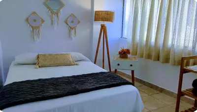 a bedroom with a bed and a lamp and a window at Apart Hotel Nazarenas in Ayacucho