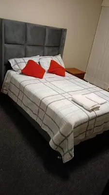 a bed with two red pillows on top of it at Departamento en Miraflores, Lima 3HAB in Lima