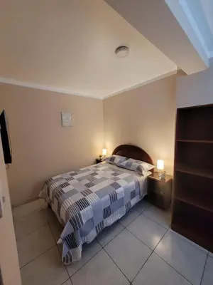 a bedroom with a bed with a striped blanket at AlojamientoMarín in Lima