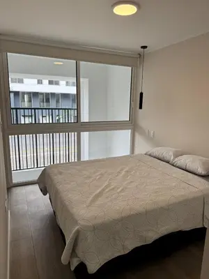 a bedroom with a bed and a large window at Exclusive apartment Barranco! in Lima