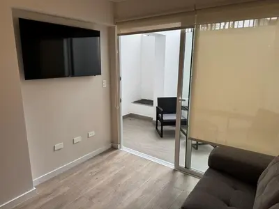 a living room with a couch and a flat screen tv at Exclusive apartment Barranco! in Lima