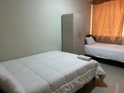 a bedroom with two beds and a large white bed at Hotel Paraiso L & M in Huánuco
