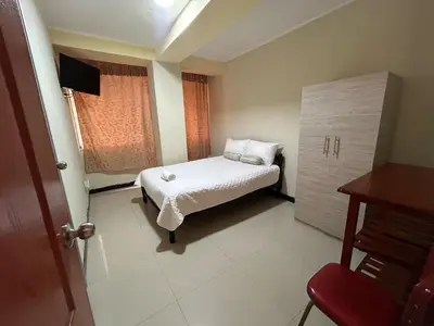 a small bedroom with a bed and a window at Hotel Paraiso L & M in Huánuco