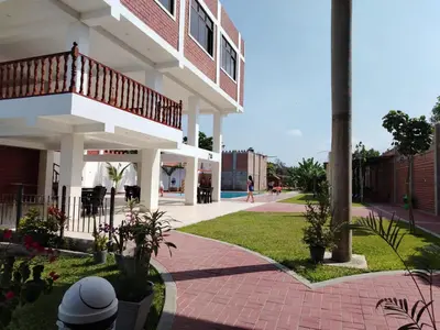 a building with a walkway in front of a building at Oliver's Garden Country Hotel in Chincha
