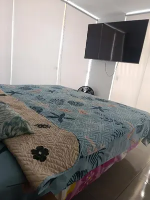 a bed with a quilt on it in a room at casa en playa de condominio mikonos in Asia