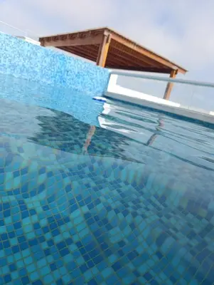 a pool of water with a house in the background at casa en playa de condominio mikonos in Asia