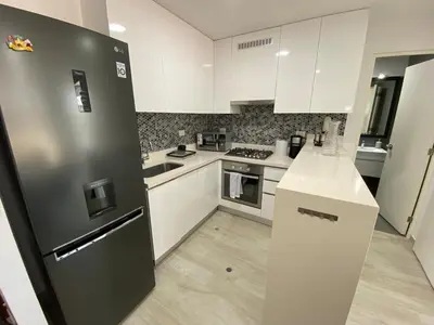 a kitchen with white cabinets and a black refrigerator at Monumental BR1 in Lima