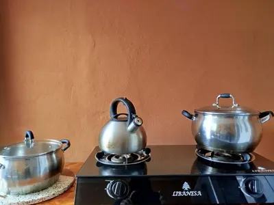 two pots and pans sitting on top of a stove at Apart Hotel Valdelomar in Ayacucho